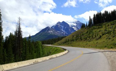 Kanada 'nın Alberta kentindeki buzul tarlalarındaki Banff Ulusal Parkı' nda güneşli bir günde Kanada 'nın kayalık dağlarına yolculuk