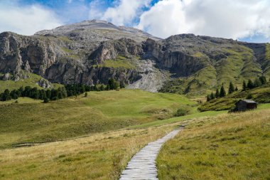 Güney Tyrol Langkofel 'deki kendine özgü Sassopiatto' ya yürüyüş yapmak için güzel bir gün. Yol kendine özgü dağa çıkar. Seyahat, macera ve tatil konsepti..