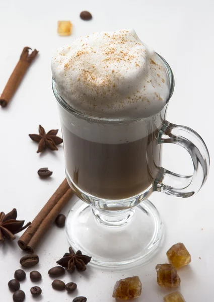 Hot Cup of coffee with whipped milk foam on the white isolated background with cinnamon sticks, stars of anise and caramel sugar. The idea for the menu and the coffee shop. Cappuccino hot — Stock Photo, Image