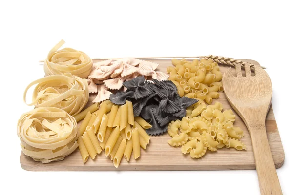 Black and golden macaroni, pastes  on a wooden board — Stock Photo, Image