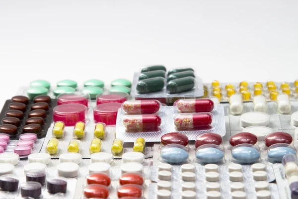 Renk tablet, kapsül ve beyaz arka plan üzerinde kabarcıklar içinde vitamin — Stok fotoğraf