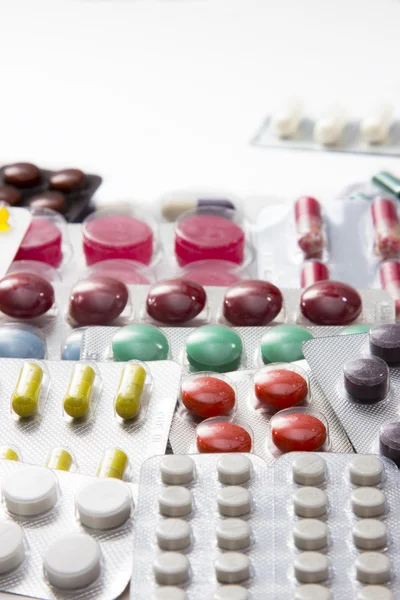 Color tablets, capsules and vitamins in blisters on the white background — Stock Photo, Image