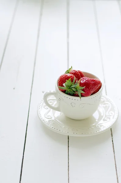 Fresas frescas en una taza rústica sobre una mesa de madera —  Fotos de Stock