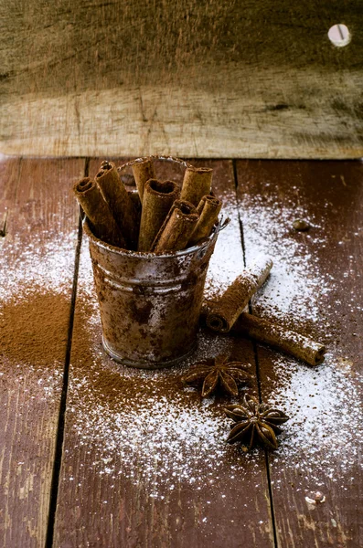 Cinnamon sticks in bucket on wooden background — Stock Photo, Image
