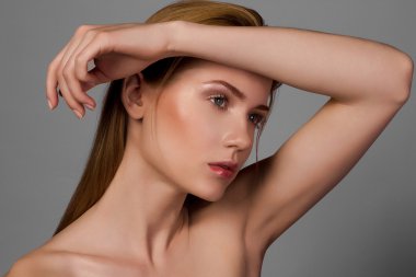 Güzel sarışın kız, güzellik modeli, büyük gözler, çıplak omuz sağ ışık çıplak makyaj, gri studio arka plan ile bir model arıyorsunuz.