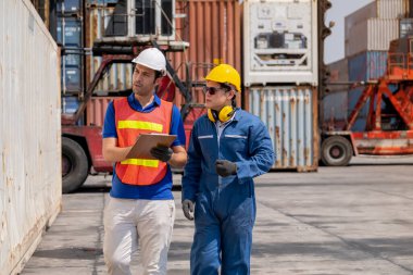 Ustabaşı ve kargo konteynırı işyerinde ürün kontrolü için birlikte yürür ve tartışırlar. Ticari Lojistik İthalat İhracat Nakliye Konsepti.
