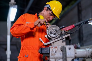 Fabrika işçisi, işyerindeki robot makinesinin tamir ve bakımını yapmak için araç kullanır. Sanayi ve teknoloji destek sistemi, çalışan kavramının çalışmasına yardımcı olur.