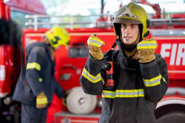 İtfaiyeci ya da itfaiyeci ayağa kalkar ve biraz hareket gösterir. Antrenman ya da eğitim süresince diğer insanlar için bazı etkinliklerin durumunu rapor eder gibi görünür..