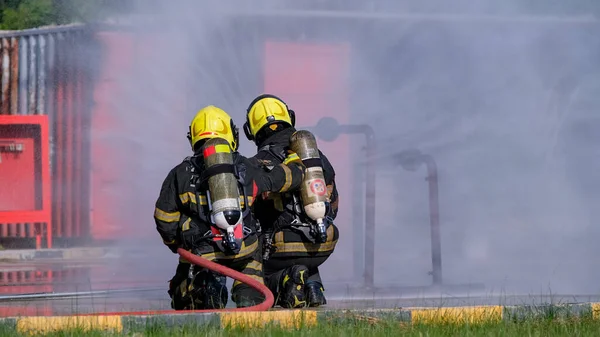 Dos Bomberos Sientan Rocían Agua Manguera Incendios Durante Práctica Entrenamiento —  Fotos de Stock