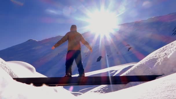 Hombre de pie y poniendo las manos en las montañas cubiertas de nieve en invierno — Vídeos de Stock