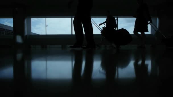 Silhuetas de pessoas com sacos no aeroporto — Vídeo de Stock