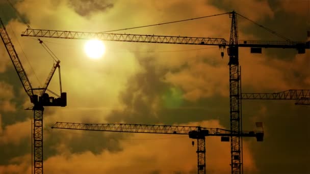 Dźwigi budowlane w budowie na zachodzie słońca — Wideo stockowe