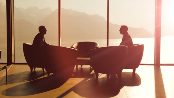 Silhouettes of two businessmen handshaking and talking — Stock Video