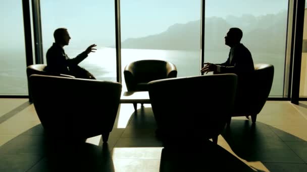 Silhouettes of two businessmen handshaking and talking — Stock Video