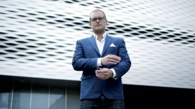 Gözlük ve göğüs üzerinde çapraz eller ile takım elbise genç işadamı