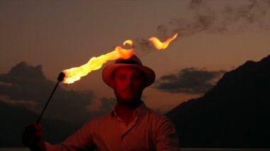 Genç adam alev meşale ile ateş gösterisi gerçekleştirme