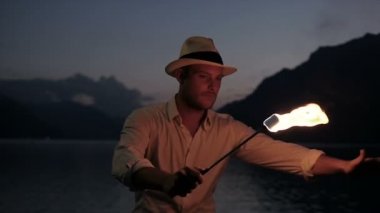 Genç adam alev meşale ile ateş gösterisi gerçekleştirme