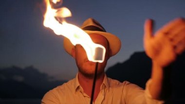 Genç adam alev meşale ile ateş gösterisi gerçekleştirme