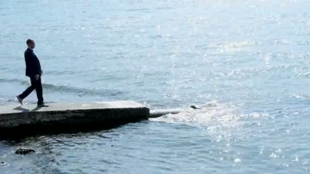 Junger kaukasischer Geschäftsmann blickt über den See. — Stockvideo