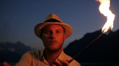 Genç adam alev meşale ile ateş gösterisi gerçekleştirme