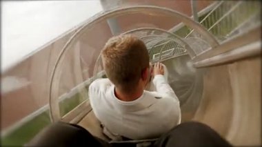 Mutlu delikanlı eğleniyor aşağı slayt üzerinde kayan