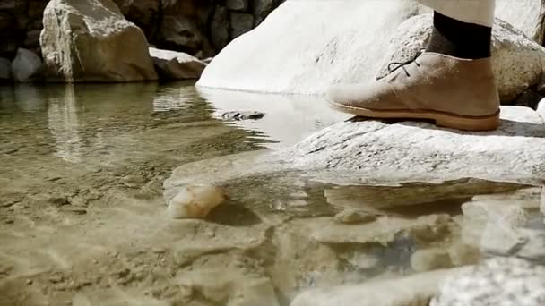 El hombre sacando piedra del agua — Vídeo de stock