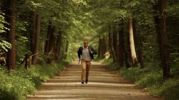 Hombre corriendo por el camino verde del parque — Vídeos de Stock