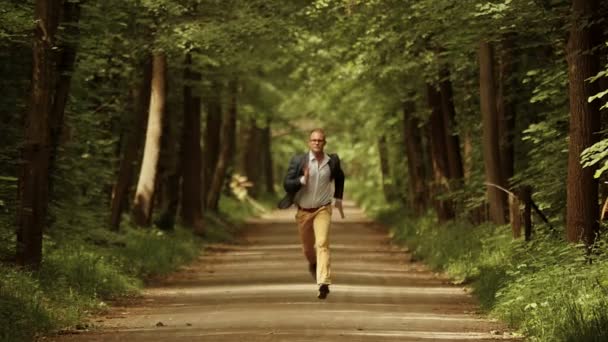 Man running on green park road — Stock Video