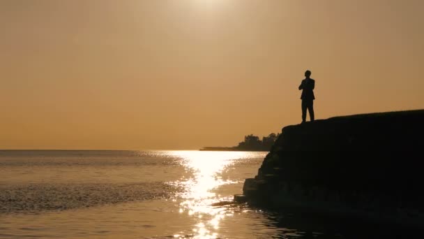 Silhouette of a man standing and looking on the lake — Stock Video