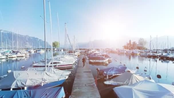 Young businessman walking among the yachts and boats — Stock Video