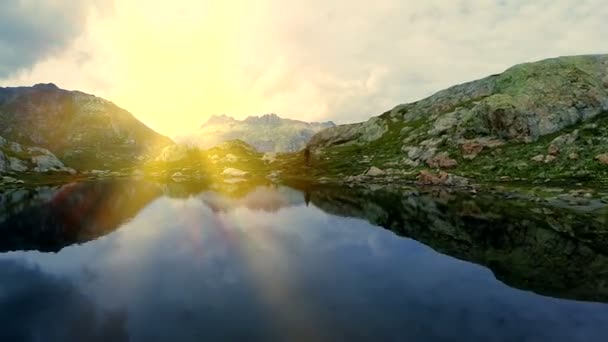 山の湖の海岸の上を歩くハイカー — ストック動画
