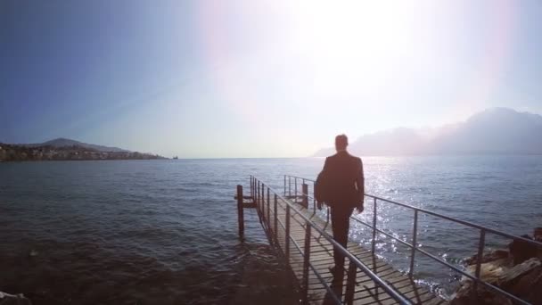 Un homme d'affaires traverse le pont en bois — Video