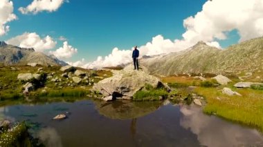 Dağ gölü kayada duran adam
