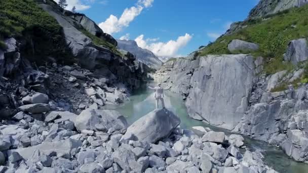 Man att höja armarna står på rock — Stockvideo