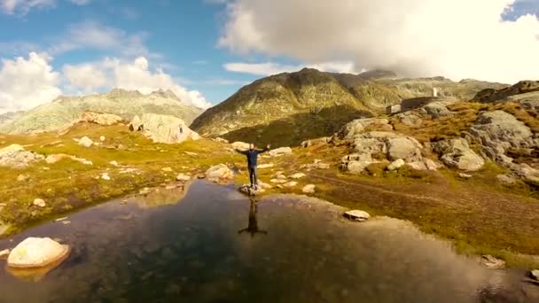 Hombre levantando las manos sobre el lago — Vídeos de Stock