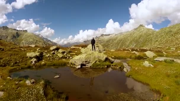 Hombre de pie en la roca en el lago de montaña — Vídeo de stock