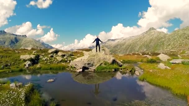 Человек поднимает руки над озером — стоковое видео