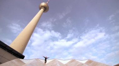 Berlin şehir kulesinin yanındaki çatıda duran kadın.
