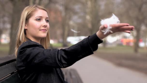 Mujer sosteniendo en la mano plumas blancas — Vídeo de stock