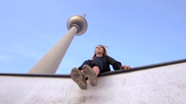 Frau entspannt sich in der Nähe des hohen Turms — Stockvideo