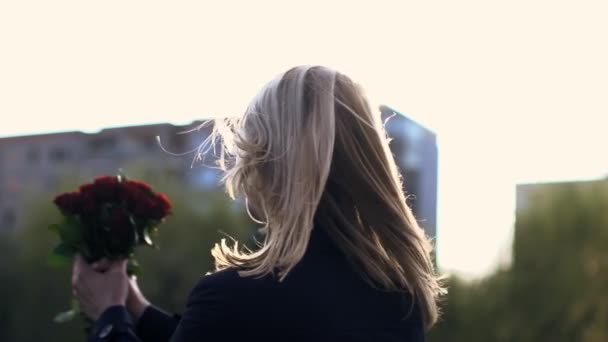 Blonde Frau dreht sich mit Rosenstrauß herum — Stockvideo