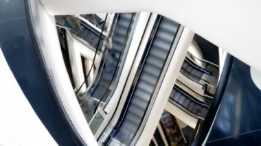 İnsanlar alışveriş merkezinde yürüyen merdiven üzerinde