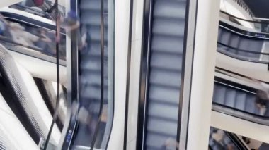 İnsanlar alışveriş merkezinde yürüyen merdiven üzerinde