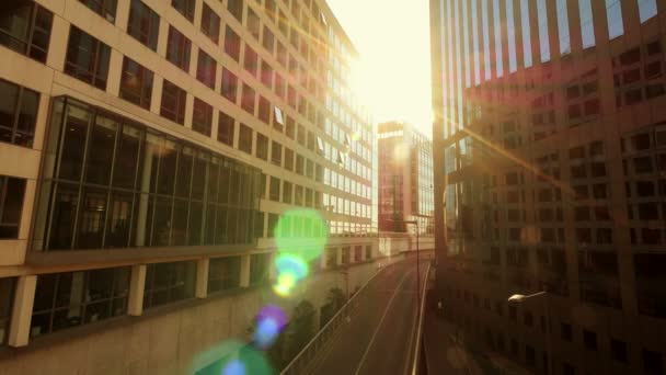 Sun flare shines trough glass buildings — Stock Video