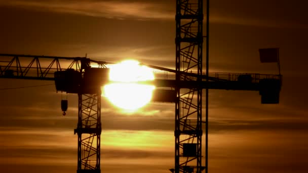 Sun crossing behind crane construction — Stock Video