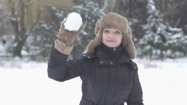 Mujer lanza bola de nieve — Vídeo de stock