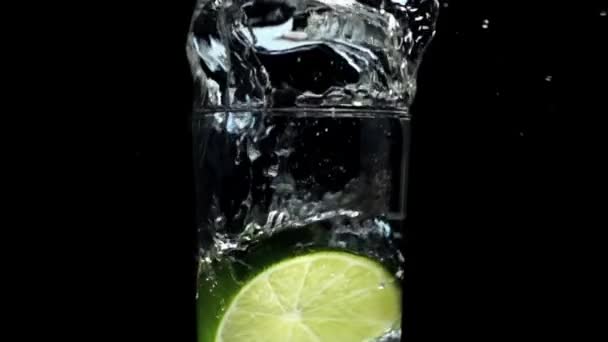Lemon splashing in glass of wate — Stock Video