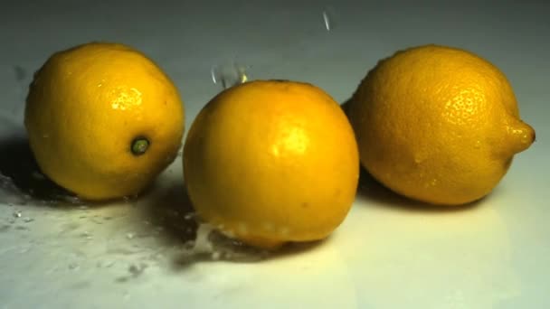 Gotas de agua cayendo sobre limones — Vídeos de Stock