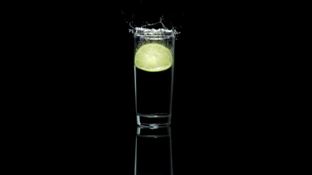 Lemon splashing in glass of wate — Stock Video