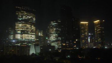 Parlak ışıklarla parıldayan modern bir şehrin nefes kesici ve çarpıcı gece manzarası.